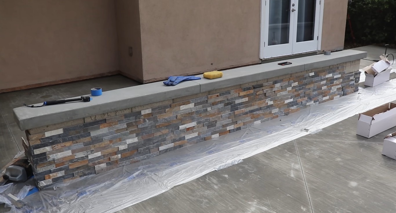 Custom stone and paver patio installation with stone veneer exterior